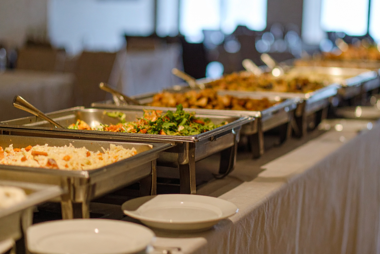 Catered buffet line with chafing dishes full of food